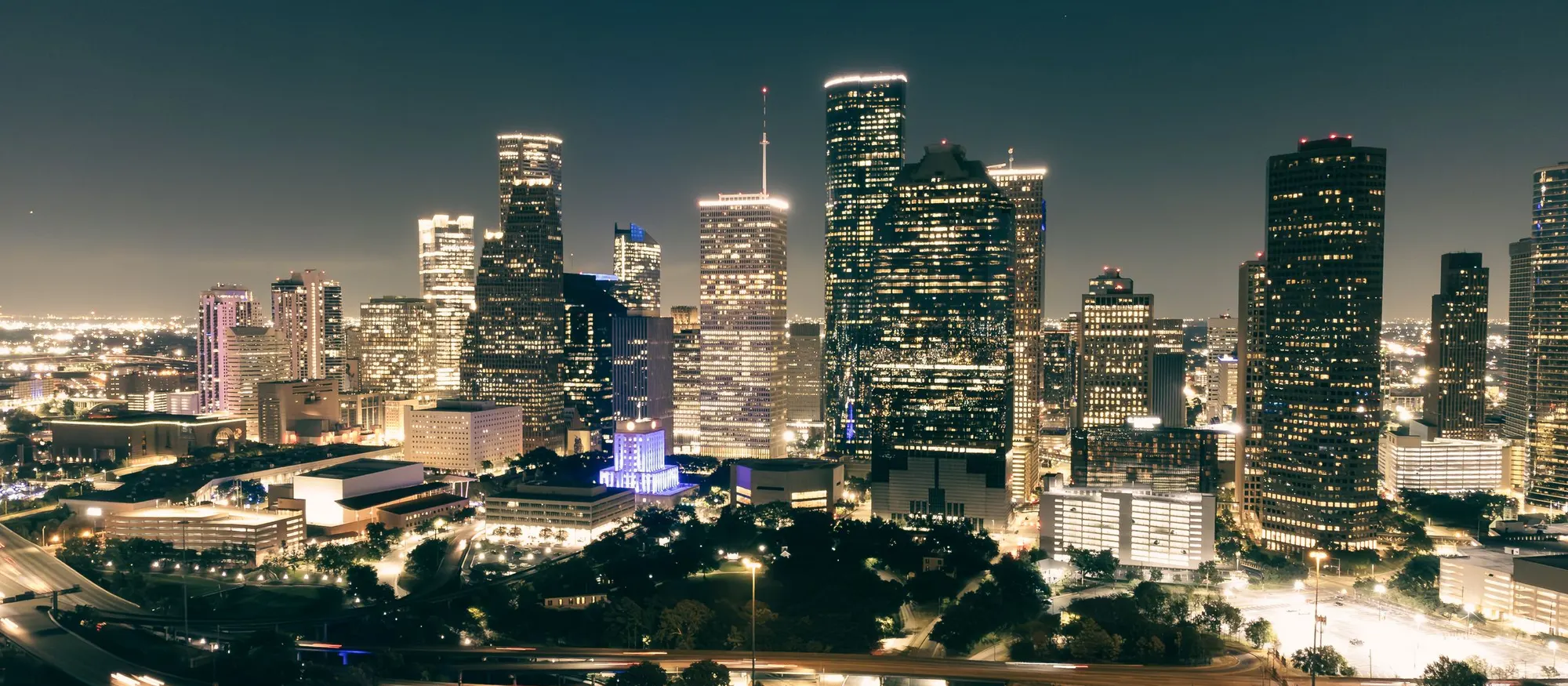 Downtown Houston at night with freeway interchanges in the foreground