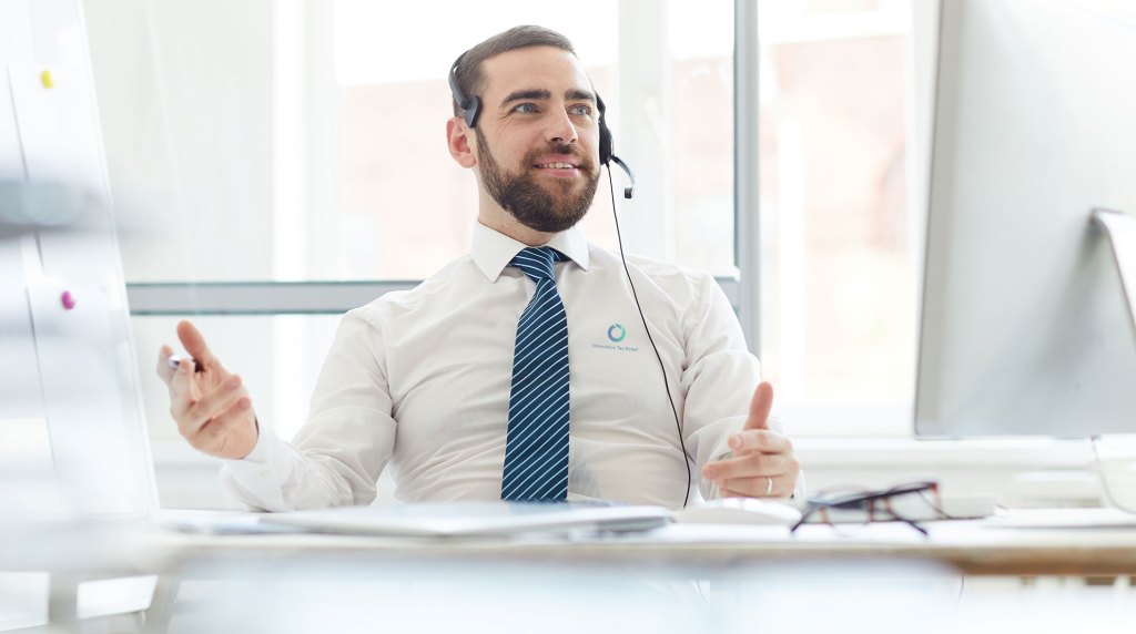 Profesional de taxes revisando con un cliente un aviso del IRS de multa relacionada con la exactitud