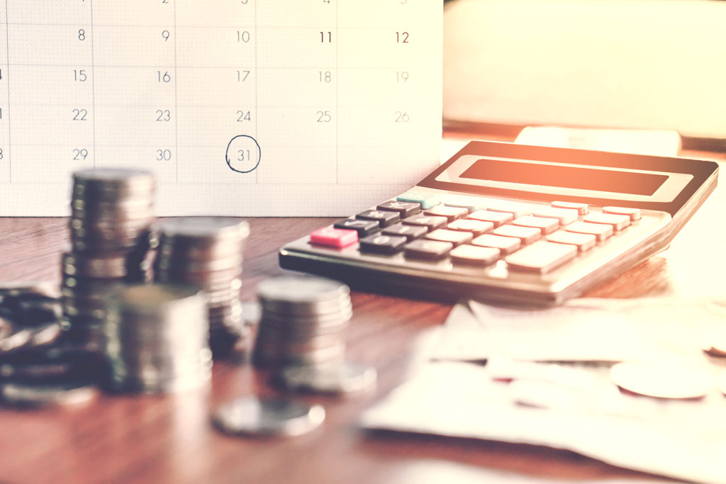 Calculator cash and calendar with date highlighted for filing tax returns 